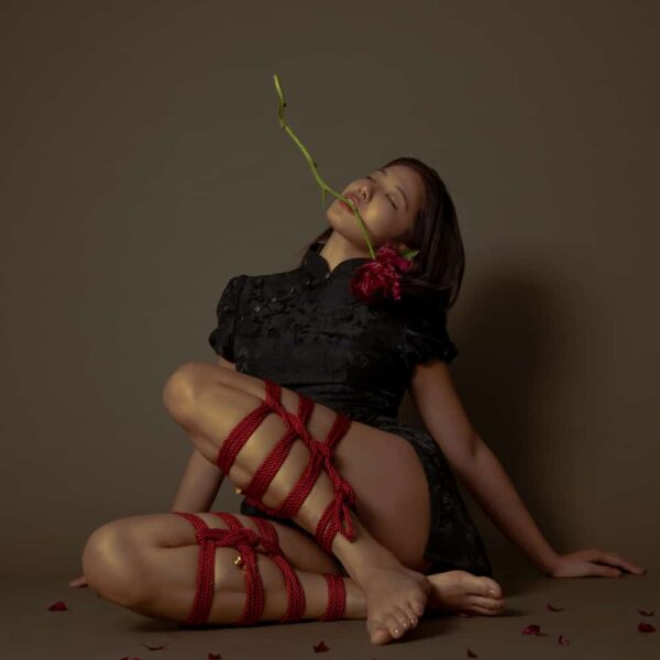 Rotes Shibari-Seil der Marke UPKO. Das Model trägt ein Seilgeflecht mit einer Länge von 10 m und einem Seildurchmesser von 6 mm.