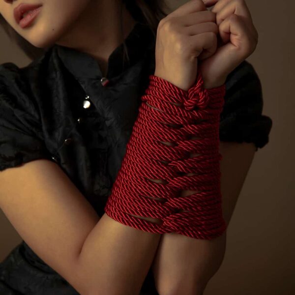 Rotes Shibari-Seil der Marke UPKO. Das Model trägt ein Seilgeflecht mit einer Länge von 10 m und einem Seildurchmesser von 6 mm.