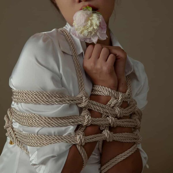 Cremefarbenes Shibari-Seil der Marke UPKO. Das Model trägt ein Seilgeflecht mit einer Länge von 10 m und einem Schnurdurchmesser von 6 mm.