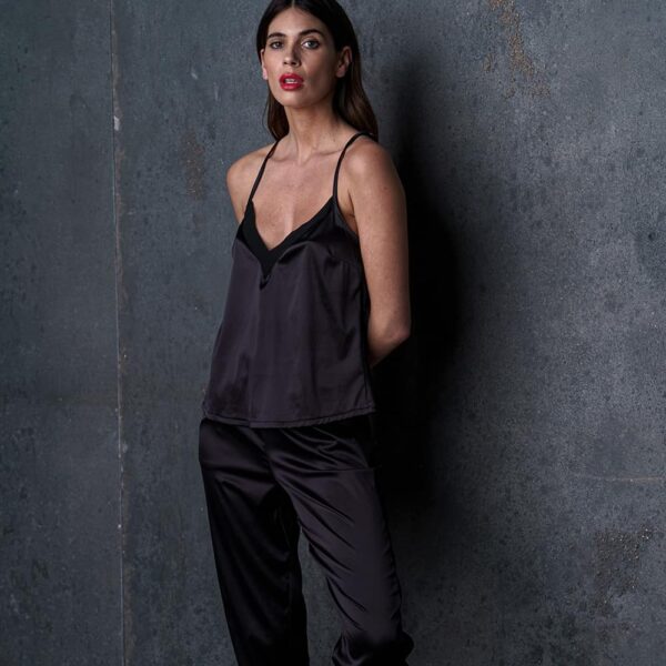 Le pantalon satin Nuit à Broadway porté par une femme, avec une ceinture froncée pour un confort optimal. Ses poches plaquées et ses bandes latérales lui donnent un look moderne et raffiné, idéal pour un ensemble homewear sexy.