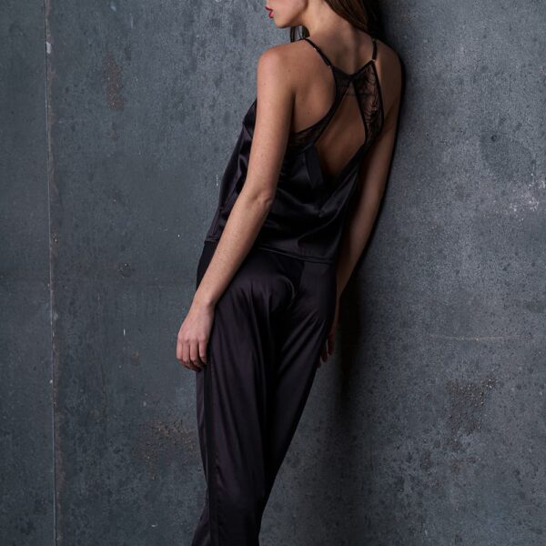 Le pantalon satin Nuit à Broadway porté par une femme, avec une ceinture froncée pour un confort optimal. Ses poches plaquées et ses bandes latérales lui donnent un look moderne et raffiné, idéal pour un ensemble homewear sexy.