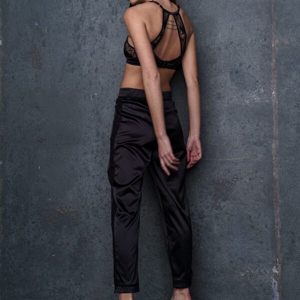 Pantalon d’intérieur satin noir Nuit à Broadway d’ATELIER AMOUR, large ceinture élastiquée froncée, poches plaquées, revers aux bas des jambes, bande sur les côtés, élégant et décontracté.