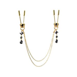 Pinces à seins Crown de la marqu Upko. Le produit est couleur or. En dessous des pinces à seins, il y a une couronne dont le centre est composé d’une pierre noire. Est suspendue aux couronnes une chaine en or composée de pierres noires mais aussi une double chaine en or qui relie les deux côtés des pinces à seins.