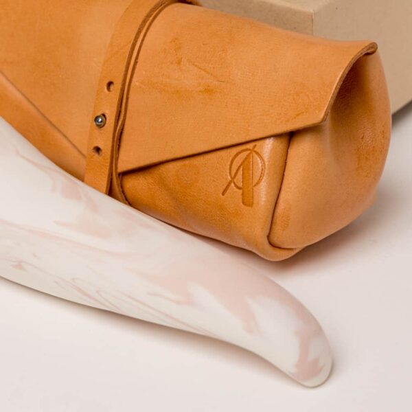 Adele Brydges - Spur Rose & Leder-ClutchADELE BRYDGES THE SPUR ROSE WEISS Orangefarbene Ledermappe mit dem Markenlogo darauf.The spur dicker oben und dünner Spitze, es ist rosa und weiß Porzellan von Adeles brydges bei brigade mondaine