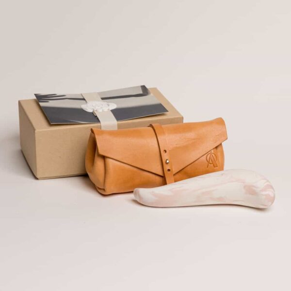 Adele Brydges - Spur Rose & Leder-Clutch Orangefarbene Ledermappe mit dem Markenlogo darauf.The spur dicker oben und dünner Spitze, es ist rosa und weiß Porzellan von Adeles brydges bei brigade mondaine