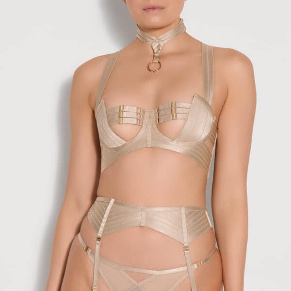 BORDELLE- Signature eine Frau trägt das Caramel Ensemble der Marke Bordelle , mit mehreren Trägern, wobei das Halsband und die Träger die Nippel bedecken.