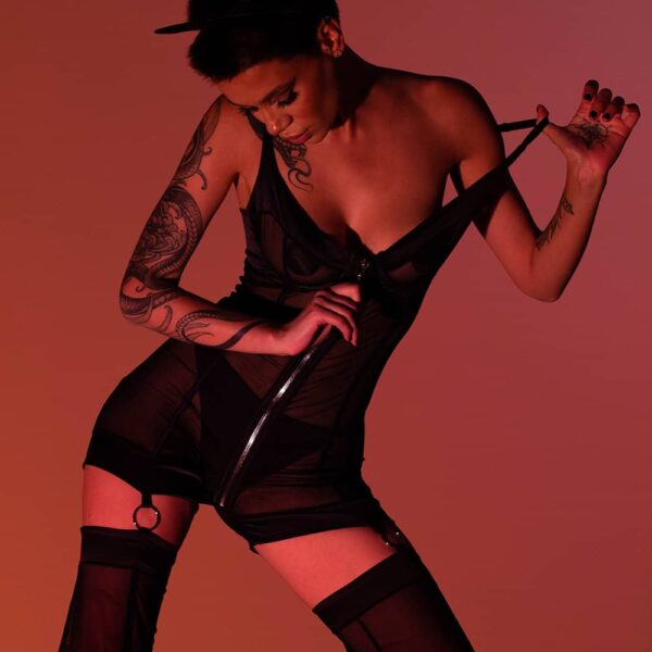 Das Kitty Pop Catsuit Set von Bæd Stories kombiniert dehnbare Seide und feines Netzgewebe für einen gewagten Look. Dank seiner Büste mit Reißverschluss-Bügel kann er kurz oder lang getragen werden. Es wird in einem Samtbeutel geliefert und vereint Sinnlichkeit und Komfort. Seien Sie mutig und trendy mit diesem provokanten Set.