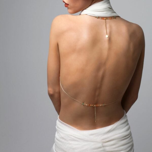 Photo d'une Femme de Dos portant un Bijou de Buste Doré avec Bijoux Swarovski et Jades avec une Tenue couleur Blanc