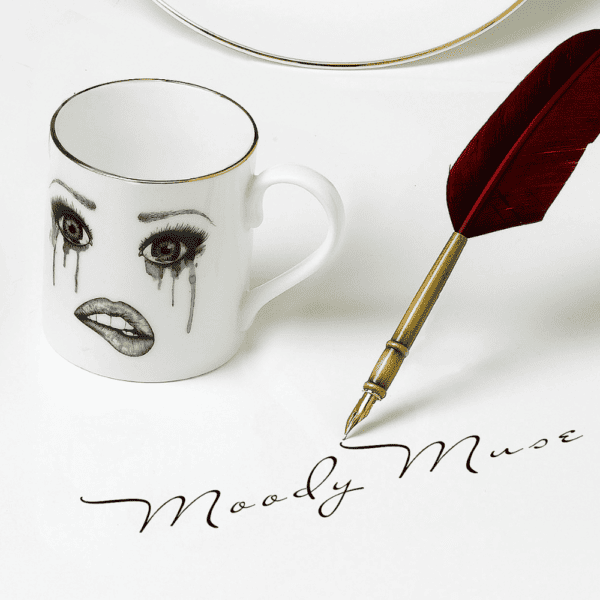 LDC - Poet Kaffeetasse Eine weiße Tasse aus chinesischem Porzellan zeigt ein melancholisches Gesicht, das sorgfältig mit Filz nachgezeichnet wurde. Dieses Gesicht drückt Traurigkeit mit fließenden Tränen und verblassendem Make-up aus, während die Unterlippe sanft gebissen wird, wodurch eine rührende und kunstvolle Komposition entsteht.
