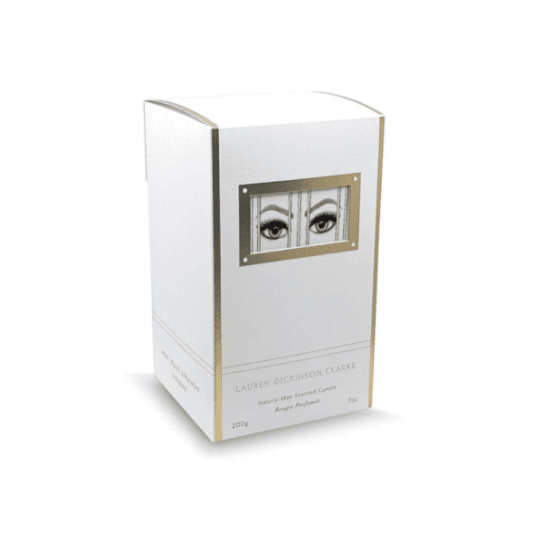 LDC - Prisoner Scented Candle The candle's packaging is white with gold accents, and features a design of eyes expressing imprisonment.