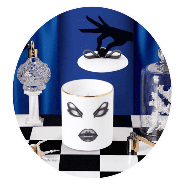LDC - Vela perfumada Prima Donna Vela perfumada Moody Muse Prima Donna sobre un damero delante de una cortina azul