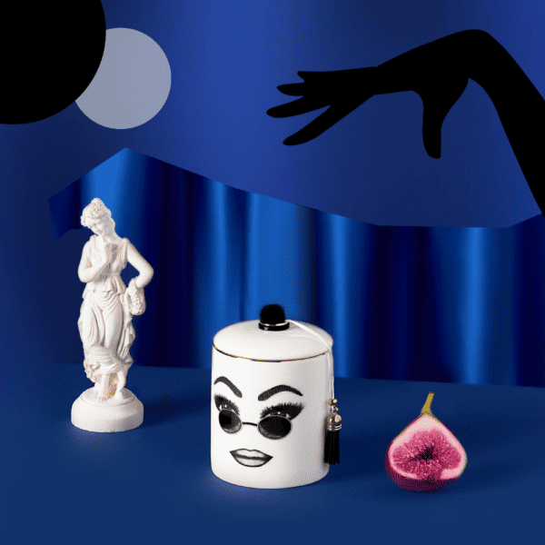 LDC - Vela perfumada Peacemaker Una vela perfumada de porcelana blanca presenta un rostro seguro de sí mismo, cuidadosamente trazado en fieltro. Este rostro expresa confianza en sí mismo, comodidad y frescura con gafas de sol redondas y un maquillaje perfectamente ejecutado.