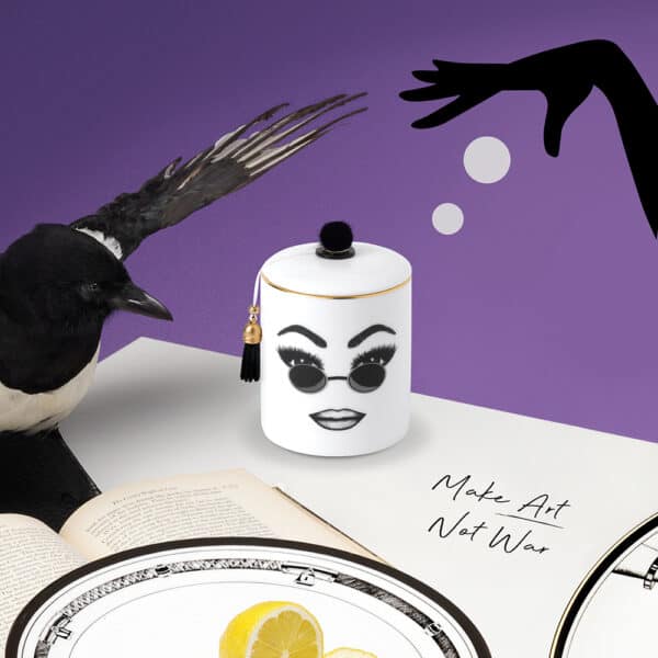 LDC - Vela perfumada Peacemaker Una vela perfumada de porcelana china blanca presenta un rostro seguro de sí mismo, cuidadosamente trazado en fieltro. Este rostro expresa confianza en sí mismo, comodidad y frescura con gafas de sol redondas y un maquillaje perfectamente ejecutado.