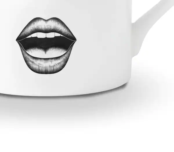 LDC - Performer Tasse à café Détail d’une tasse en porcelaine chinoise blanche présente un dessin en feutrine noire illustrant un visage surpris avec des yeux très choqués et une bouche ouverte, le tout rehaussé de détails dorés.