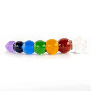 Fotografie eines Dildos auf weißem Hintergrund, er stellt einen Regenbogen dar, er ist bunt mit weiß, rot, gelb, grün, blau, marine, violett, ein Festival aus Konfetti und Farben.