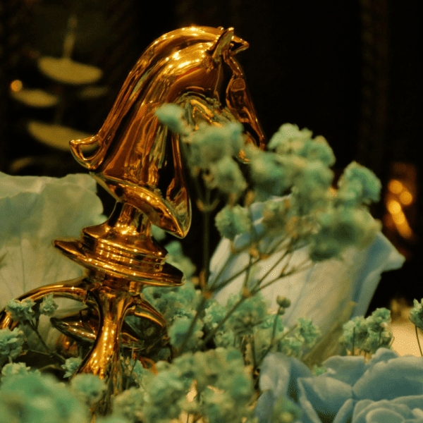 UPKO - THE CHESS Fotografie eines goldenen Springers aus einem Schachspiel Sexspielzeug in einem blauen Blumenstrauß gelegt