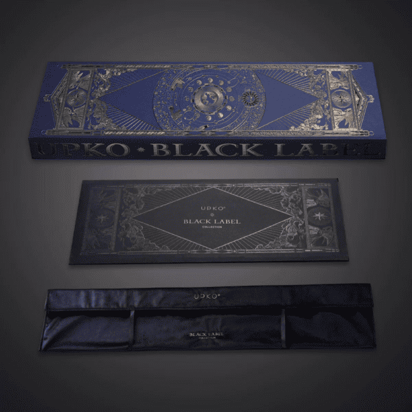 Fotografie auf grauem Hintergrund der blauen und goldenen Verpackung, Schachtel mit Samtsäckchen mit der Aufschrift "UPKO BLACK LABEL COLLECTION".