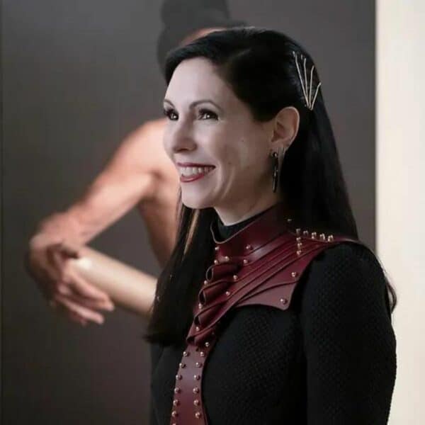 UNA BURKE - Férula corporal de cuero Imagen tomada de una película o serie en la que una mujer lleva un top Una Burke de cuero rojo.
