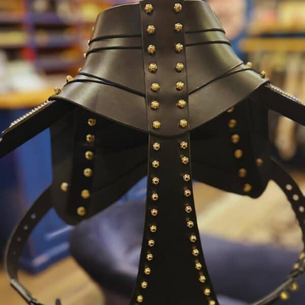 UNA BURKE - Schulterholster Leder Schwarzes Schulterholster aus Leder von Úna Burke, inspiriert von Waffenholstern, mit goldbeschichteten massiven Messingbeschlägen und Messingschrauben, die ein schickes, strukturiertes Rockstück schaffen, das von Ikonen wie Janet Jackson und Rihanna getragen wurde.