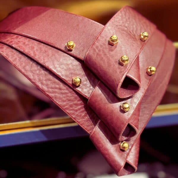 UNA BURKE - Turned Collier Merlot Collier Turned en cuir merlot d'Úna Burke, avec panneaux pliés et bandes de cuir tanné végétal, alliant chic et bondage pour une touche avant-gardiste et féminine.