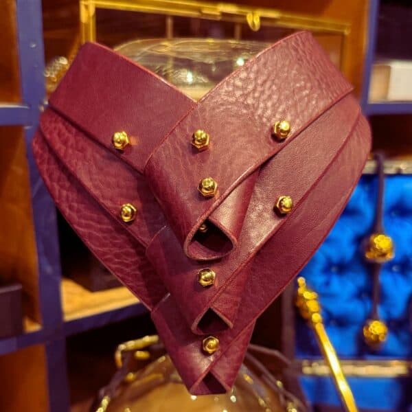 UNA BURKE - Turned Collier Merlot Collier Turned en cuir merlot d'Úna Burke, avec panneaux pliés et bandes de cuir tanné végétal, alliant chic et bondage pour une touche avant-gardiste et féminine.