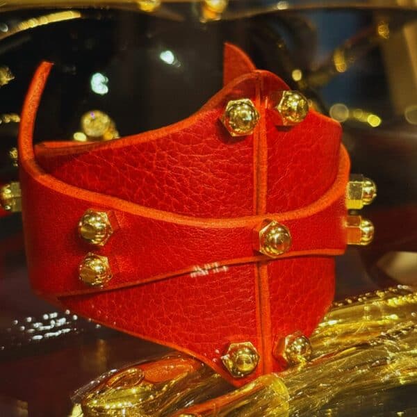 UNA BURKE - Horizontal Cuff Armband Cherry Horizontales Armband aus kirschrotem Leder von Úna Burke, mit vergoldeten Verbindungsstücken aus massivem Messing und Messingschrauben, das Rock-Chic und Bondage-Elemente vereint und so einen Hauch von gewagter Eleganz verleiht.
