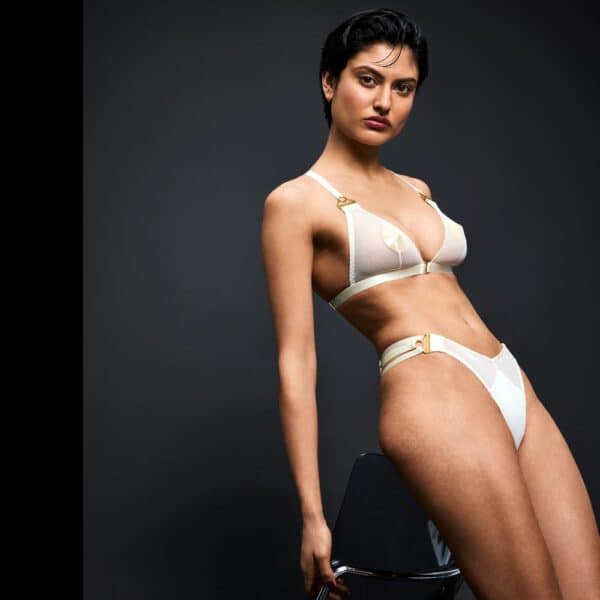 BORDELLE NEW SIGNATURE (27) Femme de 3/4 portant un Soutient-Gorge en Résille et un String en Jersey et Résille couleur Blanc avec des Nippies dorés