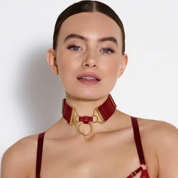Foto de una mujer de frente que lleva un collar con un anillo rojo