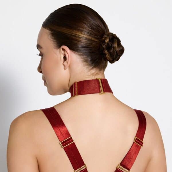 Foto de una mujer que lleva un collar con un anillo rojo.