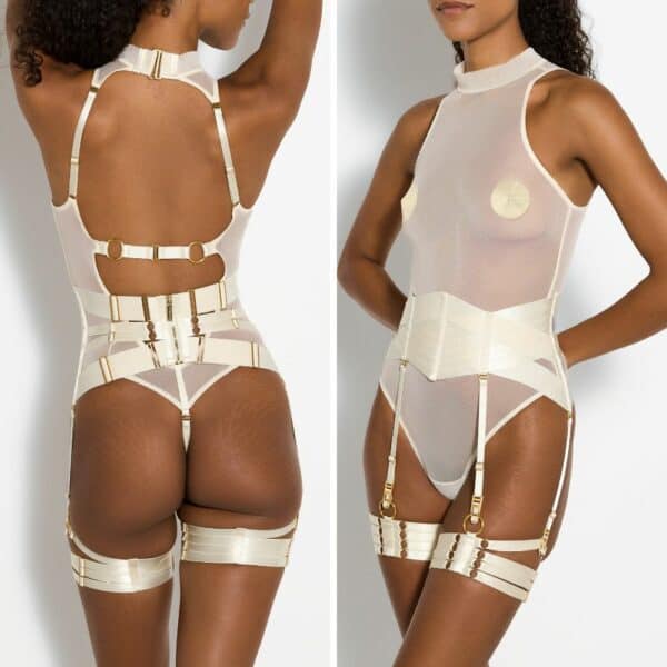 Photo of a front and back woman wearing a fishnet bodysuit, a garter belt and cream Bondage Webbed garters with gold nipples.