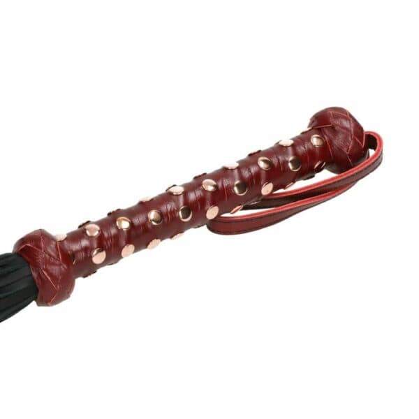 Détail du Packshot d'un Martinet avec un Manche en Cuir Rouge et Lanières en Cuir Noir