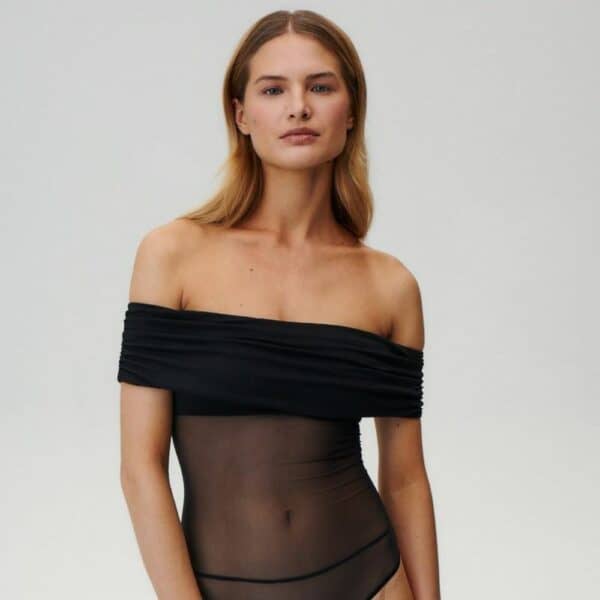 UNDRESS CODE - LIBRA Bodysuit Photo d'une Femme de Devant portant un Body Epaules Nues en Résille avec un Drapé en Viscose Opaque au niveau de la Poitrine et des Bras couleur Noir