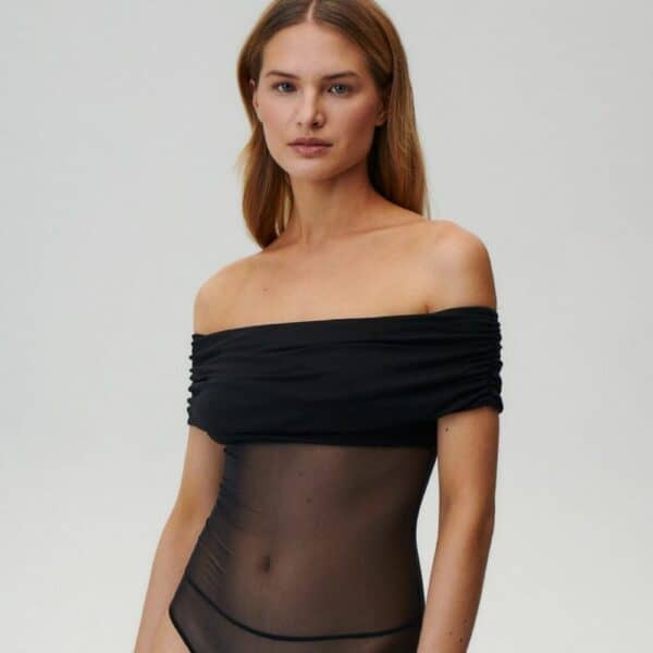 UNDRESS CODE - LIBRA Bodysuit Photo d'une Femme de Devant portant un Body Epaules Nues en Résille avec un Drapé en Viscose Opaque au niveau de la Poitrine et des Bras couleur Noir