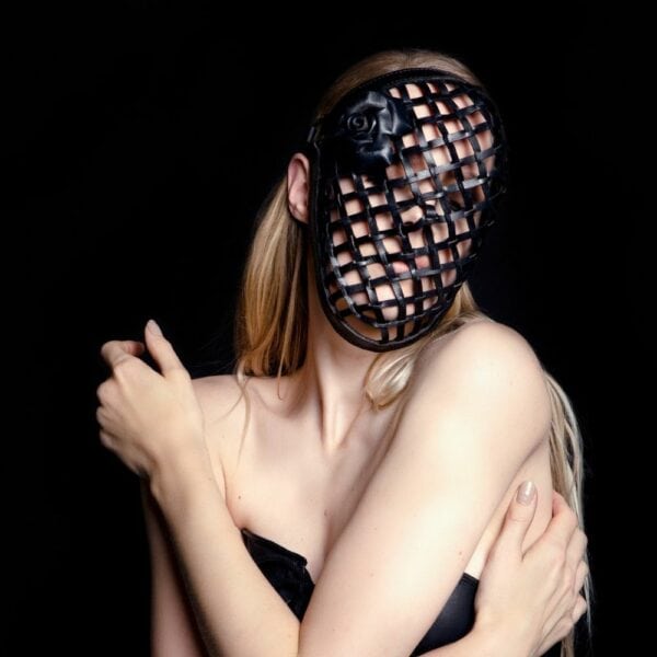 Photo Woman wearing Vegetal Leather Mask with Finely Woven Black Leather Corners, Adorned with a Pair of Removable Black Leather Roses The Mask's Contour is Lightly Padded in Handmade Suede