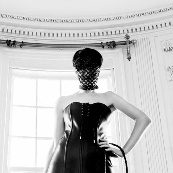 Foto Frau Kleid Leder Stil Korsett Detail Schnürsenkel in Oben und Unten mit Bondage Maske Schwarzes Leder und Peitsche Schlangenleder Schwarz Glänzendes Leder