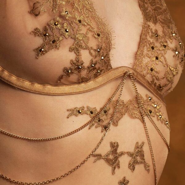 Hervé by Céline Marie Luxury Lingerie BRIGADE MONDAINE (26) Detail of a 3/4-length woman wearing a flesh-colored bodysuit with gold embroidery.