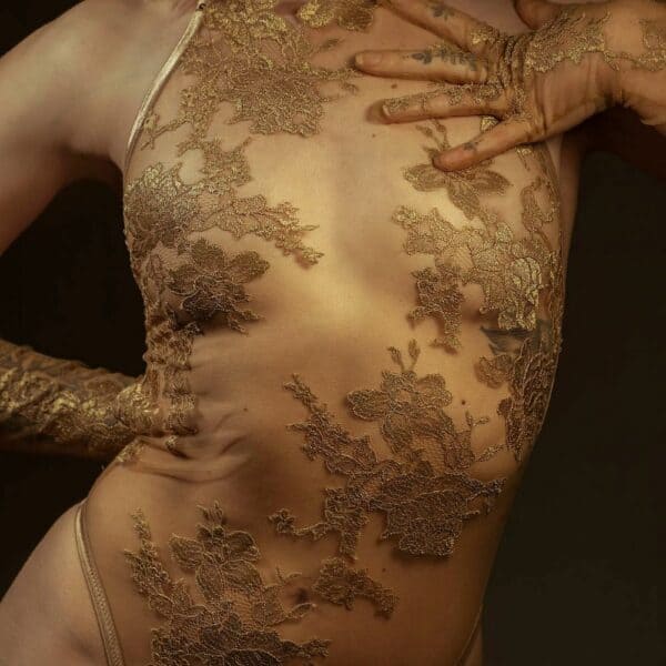 El body halter AMMALIE realza la silueta con su efecto segunda piel y su sutil brillo dorado. Confeccionado en punto ilusión ultratransparente, se ciñe al cuerpo con delicadeza. Su aplicación de encaje francés Leavers en oro rosa, cortada y cosida a mano, añade un toque precioso. Los tirantes dorados ajustables y los herrajes chapados en oro de 24 quilates garantizan un ajuste perfecto. Para un confort óptimo, el interior está forrado de algodón orgánico de bambú.