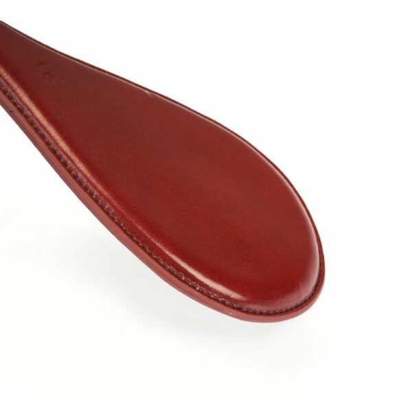 Detailaufnahme eines ovalen Paddle aus rotem Leder