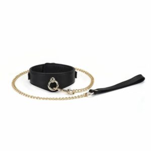 Dark Secret Sklavenhalsband aus schwarzem Leder mit Leine aus goldener Kette. Verstellbar mit Metallschnallen und kompatibel mit diversem BDSM-Zubehör. Entworfen für raffinierte Dominanzspiele.