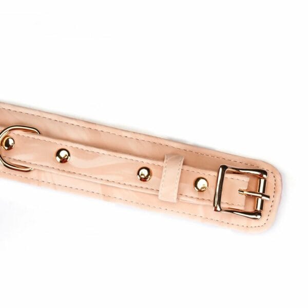 Bondage-Halsband Pink Boudoir Amor aus veganem Kunstleder in rosa und schwarz. Vergoldete Beschläge, drei D-Ringe zur Befestigung. Mit goldfarbener Kettenleine, elegant und verstellbar für eine raffinierte Dominanz.