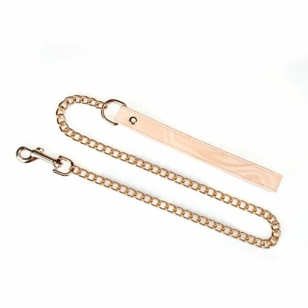Bondage-Halsband Pink Boudoir Amor aus veganem Kunstleder in rosa und schwarz. Vergoldete Beschläge, drei D-Ringe zur Befestigung. Mit goldfarbener Kettenleine, elegant und verstellbar für eine raffinierte Dominanz.