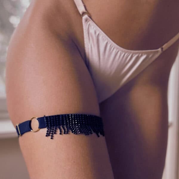 MAISON LIBERTINE - Jarretière Desire Noir Femme de 3/4 portant une Jarretière élastique Noire avec Franges de Strass Noirs