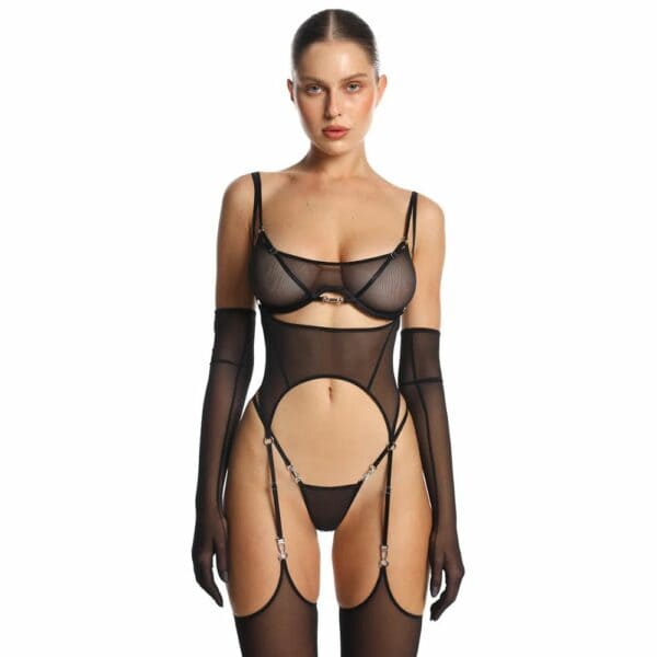 Frau Trägt Ein Schwarzes Semi-Transparentes Mesh-Set, bestehend aus BH, String und Strapsgürtel mit passenden Mesh-Strümpfen
