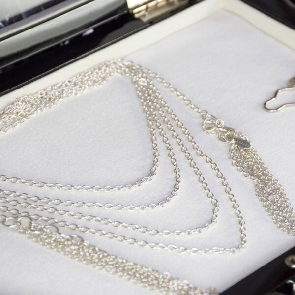 Collier Lalita en argent massif, chaîne enroulée quatre fois autour du cou avec pampilles suspendues de chaque côté. Une pièce élégante et fluide, apportant un effet raffiné et moderne à toute tenue.