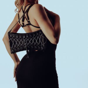Robe convertible en bambou avec soutien-gorge harnais amovible, associée à un sac à main en cuir corseté avec détails en argent sterling et intérieur en daim violet. Audace, élégance et modularité.
