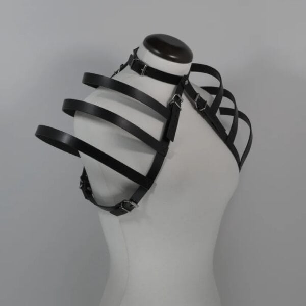 NIAR House - Choker Geschirr 73863 Seitenansicht des Leder-Harness 73863 an einer weißen Schaufigur, die die frei fallenden Riemen an den Schultern und das skulpturale Design des Harness hervorhebt. Auch das verstellbare Choker-Halsband, das mit dem Ensemble verbunden ist, ist zu sehen und sorgt für eine gewagte und moderne Silhouette.