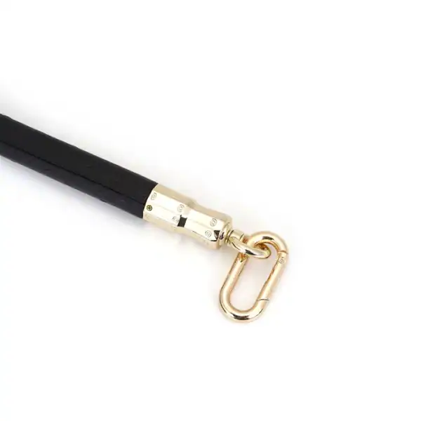 Ostrich-embossed black leather spreader bar with quick-release clips and gold finish. Elegant BDSM control accessory.