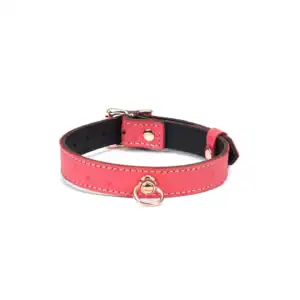 Choker O in cherry-pink leather, ostrich-skin embossed, with central ring. Rose gold metal finish, adjustable with gold buckle. A chic fetish accessory to mark belonging.
