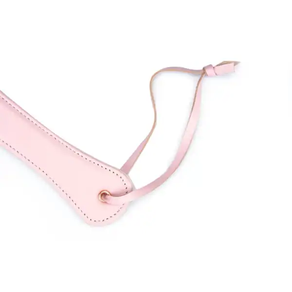 Rosafarbenes Lederpaddle aus der Fairy-Kollektion, hergestellt aus weißem und rosafarbenem Lammleder mit roségoldenen Akzenten. Ein raffiniertes BDSM-Accessoire für kontrollierte und elegante Spanking-Spiele.