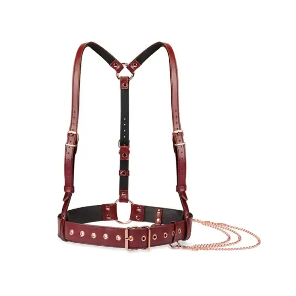 Harnais buste en cuir rouge vin avec finitions or rose. Design ajustable, inspiré des bretelles d’ouvrier, avec chaîne décorative à la taille. Élégant et confortable, idéal pour jeux BDSM.